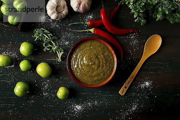 Tkemali Sauce  traditionelle georgische Küche  grüne Kirschpflaume  mit Zutaten für die Sauce  Koriander  Minze  scharfer Pfeffer  Knoblauch  auf einem Holztisch  Nahaufnahme  rustikal  Lebensmittel Hintergrund  keine Menschen  selektiver Fokus  Sauce  grüne Sauce  tkemali  georgische Küche  hausgemacht