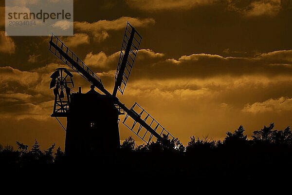 Windmühlen Silhouette bei Sonnenuntergang mit rotem Himmel und Wolken dahinter  Cley next to the sea  Norfolk  England  Großbritannien  Europa