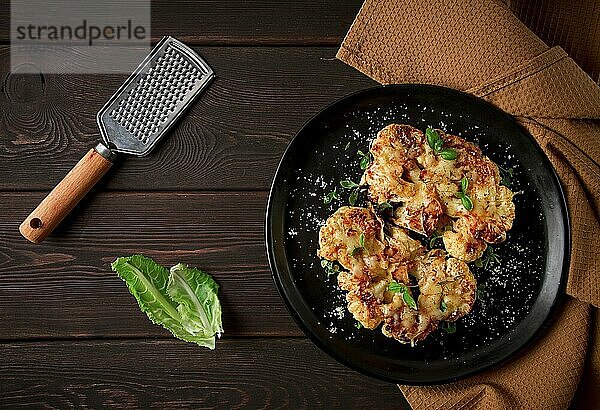 Steak  Blumenkohl  mit Käse  Gewürzen  hausgemacht  auf einem Holztisch  dunkler Hintergrund  Nahaufnahme  Draufsicht  selektiver Fokus  keine Personen