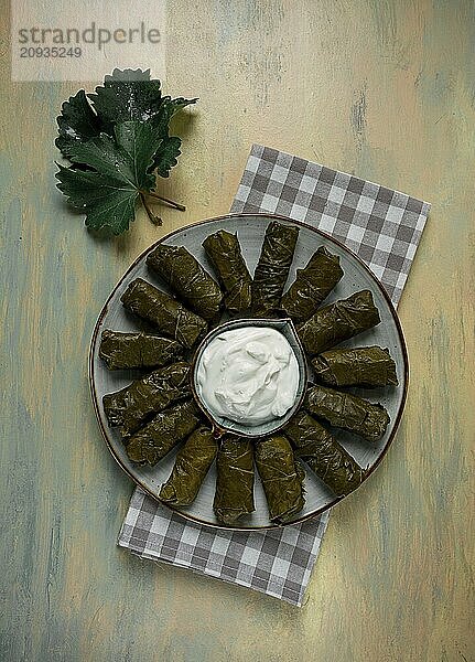 Dolma  Kohlrouladen in Traubenblättern  traditionelles armenisches Gericht  mit weißer Soße  Draufsicht  Nahaufnahme  selektiver Fokus