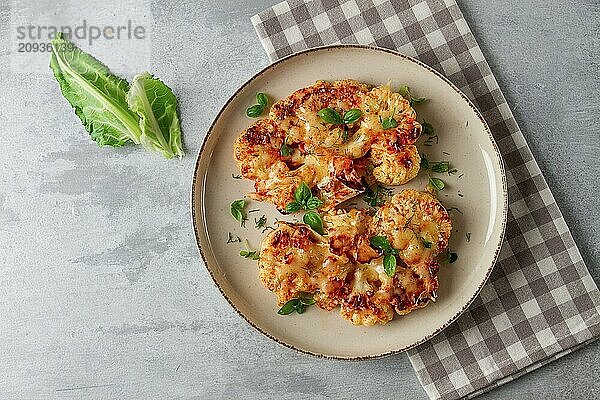 Steak  Blumenkohl  mit Käse  Gewürzen  hausgemacht  auf einem hellgrauen Tisch  Nahaufnahme  Draufsicht  selektiver Fokus  keine Personen