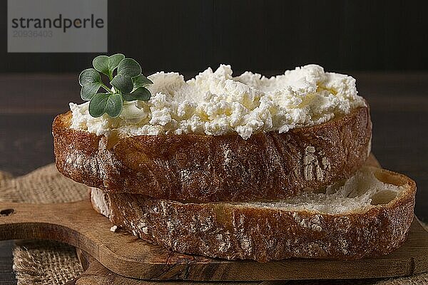 Sandwich  mit Frischkäse  hausgemacht  auf einem Schneidebrett  rustikal  ohne Menschen  selektiver Fokus  Frühstück