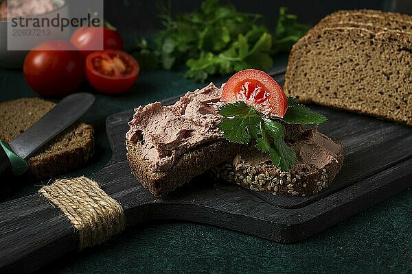 Leberpastete auf Roggenbrot  Frühstück  Nahaufnahme  dunkler Hintergrund  keine Personen  selektiver Fokus