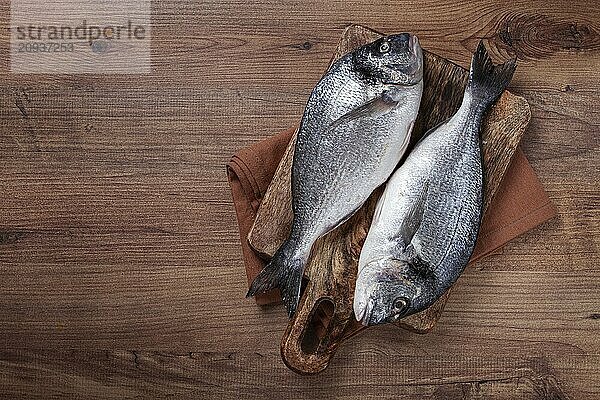 Fresh raw dorado fish  on a chopping board  wooden table  top view  two pieces  no people