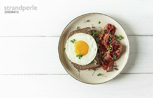 Frühstück  Spiegelei mit Speck  mikro grün  auf einem hellen Hintergrund  keine Menschen  selektiver Fokus