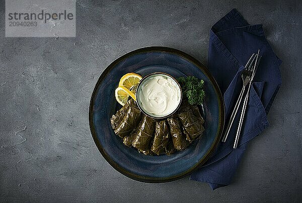 Dolma  Kohlrouladen  Traubenblätter mit Füllung  weiße Soße  Zitrone und Kräuter  rustikal  selektiver Fokus  keine Menschen