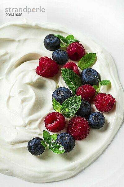 Frühstück  Joghurt mit frischen Beeren  Himbeeren und Heidelbeeren  auf einem weißen Hintergrund  selektiver Fokus  keine Menschen  gesunde Lebensmittel