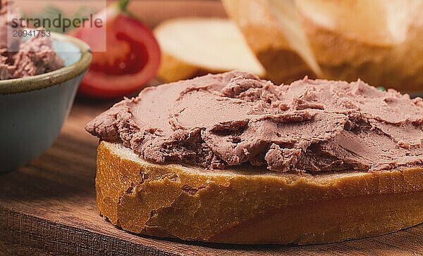 Leberpastete  auf Weißbrot  auf einem hölzernen Hintergrund  Frühstück  Nahaufnahme  keine Menschen  selektiver Fokus  Pasticcio  Pastete