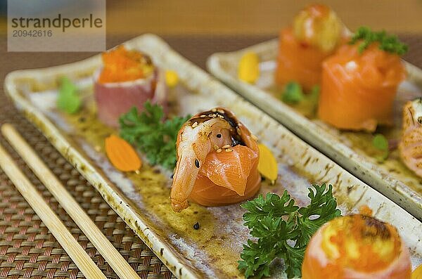 Teller mit verschiedenen Geschmacksrichtungen von eleganten Sushi dekoriert. Selektiver Fokus