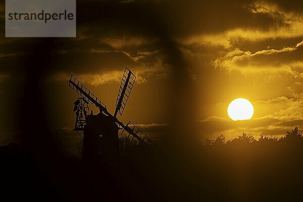 Windmühlensilhouette bei Sonnenuntergang mit rotem Himmel und Wolken  Cley next to the sea  Norfolk  England  Großbritannien  Europa