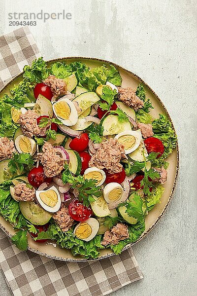 Thunfischsalat  Gemüsesalat mit Wachteleiern  Kopfsalat  roten Zwiebeln und Gurken  auf einem hellgrauen Tisch  Keto Food  Lifestyle  gesunde Ernährung  selektiver Fokus  Draufsicht  keine Menschen