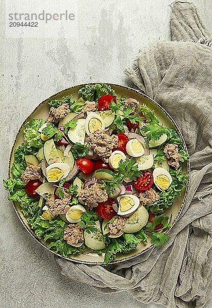 Thunfischsalat  Gemüsesalat mit Wachteleiern  Kopfsalat  roten Zwiebeln und Gurken  auf einem hellgrauen Tisch  Keto Food  Lifestyle  gesunde Ernährung  selektiver Fokus  Draufsicht  keine Menschen