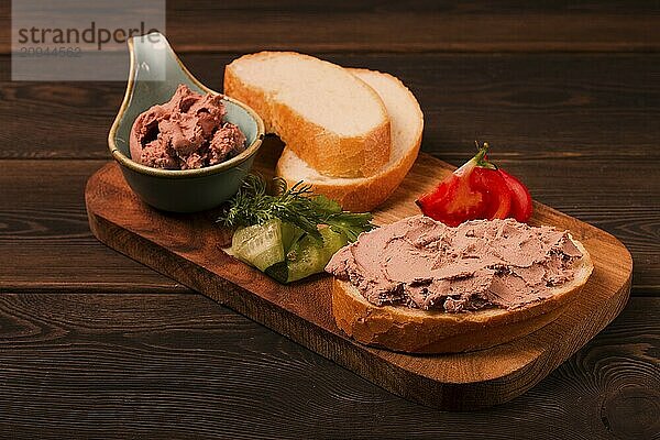 Leberpastete  auf Weißbrot  auf einem hölzernen Hintergrund  Frühstück  Nahaufnahme  keine Menschen  selektiver Fokus  Pasticcio  Pastete