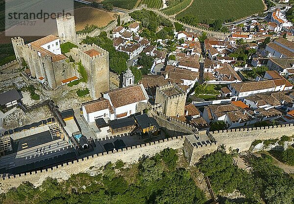 Luftaufnahme einer historischen Stadt mit einer Burg und umgebenden Stadtmauern  eingebettet in eine hügelige und grüne Landschaft  Stadt  Burg  Castelo de Óbidos  Stadtmauer  Óbidos  Obidos  Oeste  Centro  Estremadura  Portugal  Europa