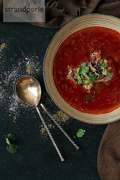 Traditionelles georgisches Gericht scharfe Tomate  Kharcho Suppe  auf dunklem Hintergrund  ohne Menschen  Ansicht von oben