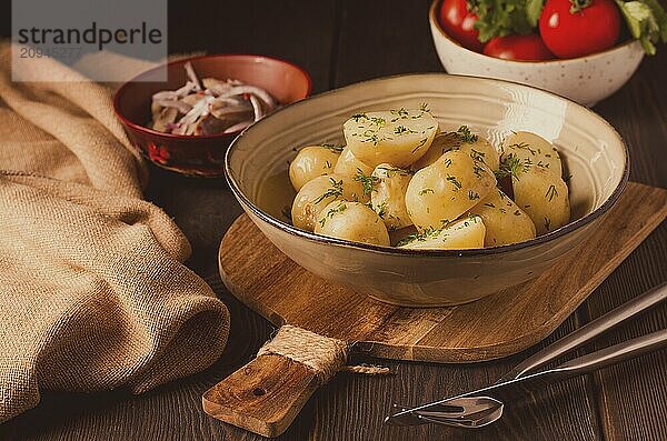 Frisch gekochte  neue Kartoffeln  mit Dill  auf einem Holztisch  selektiver Fokus. Nahaufnahme  Tonung  keine Personen