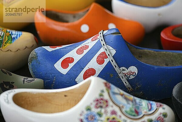 Koog aan de Zaan  Niederlande. Juli 2022. Bunte Holzschuhe vor dem Hintergrund einer Holzwand. Beliebte Souvenirs. Traditionen der Niederlande. Nahaufnahme. Selektiver Fokus