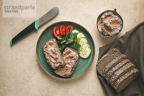 Leberpastete auf Roggenbrot  Frühstück  Nahaufnahme  beiger Hintergrund  keine Personen  selektiver Fokus