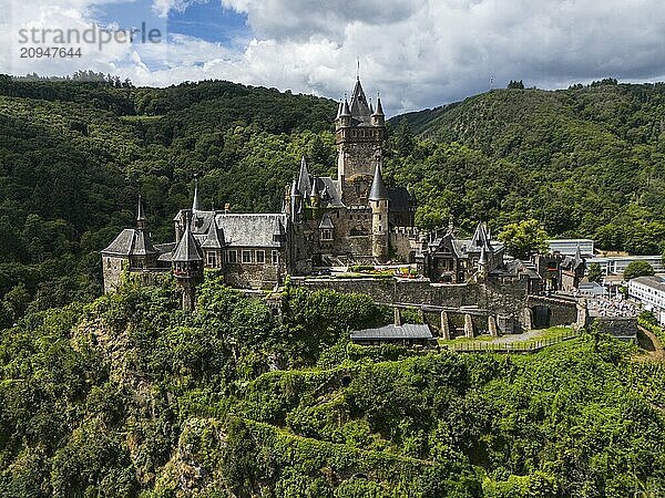 Eine historische Burg auf einem grünen  bewaldeten Hügel unter einem bewölkten Himmel  Luftaufnahme  Reichsburg  Cochem  Cochem-Zell  Mosel  Rheinland-Pfalz  Deutschland  Europa