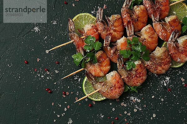 Shrimp kebab  with spices  lime  on wooden skewers  top view  no people