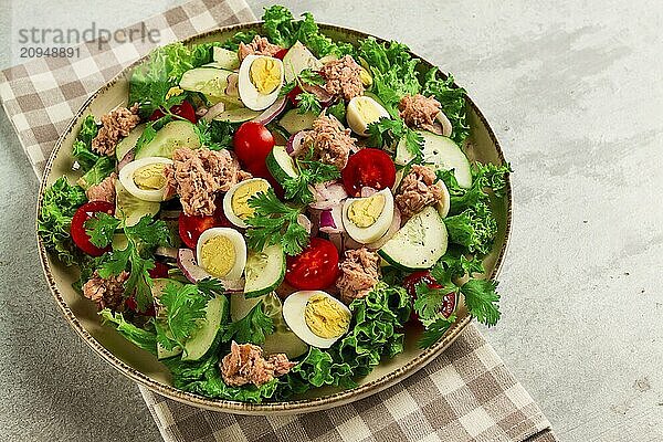 Thunfischsalat  Gemüsesalat mit Wachteleiern  Kopfsalat  roten Zwiebeln und Gurken  auf einem hellgrauen Tisch  Keto Food  Lifestyle  gesunde Ernährung  selektiver Fokus  Draufsicht  keine Menschen