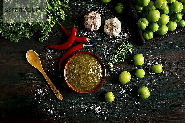 Tkemali Sauce  traditionelle georgische Küche  grüne Kirschpflaume  mit Zutaten für die Sauce  Koriander  Minze  scharfer Pfeffer  Knoblauch  auf einem Holztisch  Nahaufnahme  rustikal  Lebensmittel Hintergrund  keine Menschen  selektiver Fokus  Sauce  grüne Sauce  tkemali  georgische Küche  hausgemacht