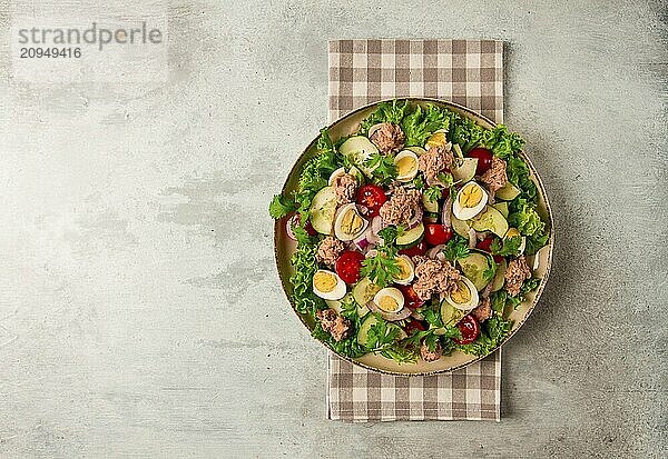 Thunfischsalat  Gemüsesalat mit Wachteleiern  Kopfsalat  roten Zwiebeln und Gurken  auf einem hellgrauen Tisch  Keto Food  Lifestyle  gesunde Ernährung  selektiver Fokus  Draufsicht  keine Menschen