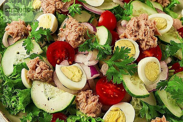 Thunfischsalat  Gemüsesalat mit Wachteleiern  Kopfsalat  roten Zwiebeln und Gurken  auf einem hellgrauen Tisch  Keto Food  Lifestyle  gesunde Ernährung  selektiver Fokus  Draufsicht  keine Menschen