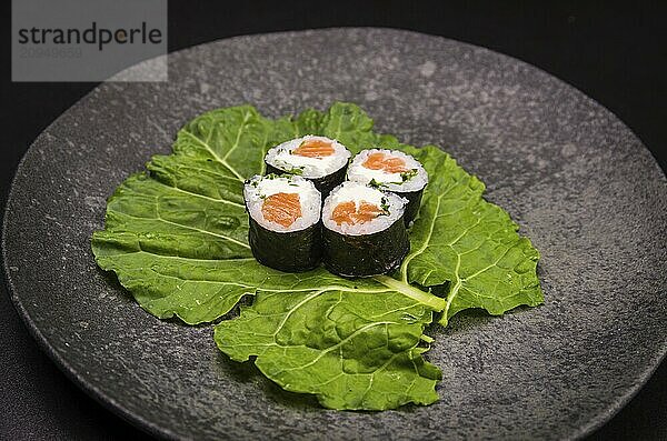 Perfektes Sushi  traditionelle japanische Küche. Leckere Hossomaki auf dem dekorierten Teller  schwarzer Hintergrund