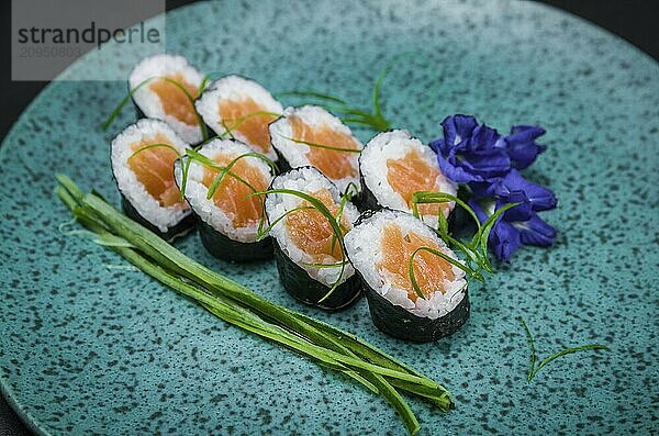 Perfektes Sushi  traditionelle japanische Küche. Leckere Hossomaki auf dem dekorierten Teller  schwarzer Hintergrund