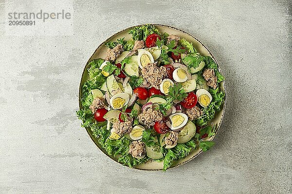 Thunfischsalat  Gemüsesalat mit Wachteleiern  Kopfsalat  roten Zwiebeln und Gurken  auf einem hellgrauen Tisch  Keto Food  Lifestyle  gesunde Ernährung  selektiver Fokus  Draufsicht  keine Menschen