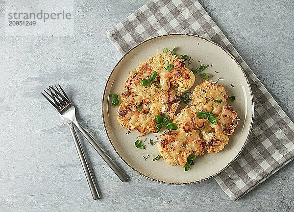 Steak  Blumenkohl  mit Käse  Gewürzen  hausgemacht  auf einem hellgrauen Tisch  Nahaufnahme  Draufsicht  selektiver Fokus  keine Personen