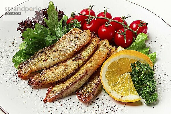 Gebratenes Tilapia Fischfilet  in Gewürzen  mit Kirsche und Salat  auf einem weißen Teller  hausgemacht  ohne Personen