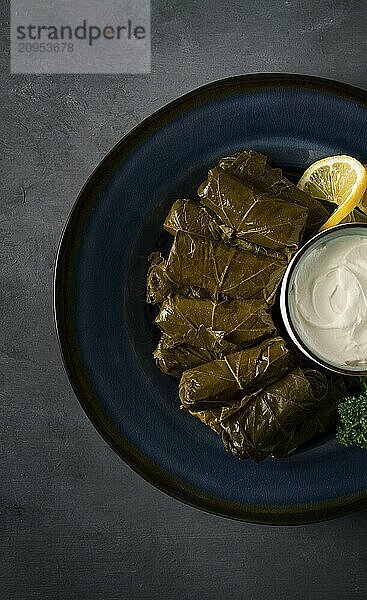 Dolma  Kohlrouladen  Traubenblätter mit Füllung  weiße Soße  Zitrone und Kräuter  rustikal  selektiver Fokus  keine Menschen