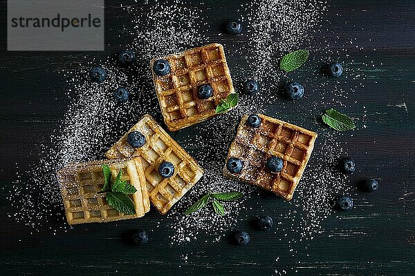 Wiener Waffeln mit Blaubeeren  vor dunklem Hintergrund  Frühstück  keine Menschen  selektiver Fokus