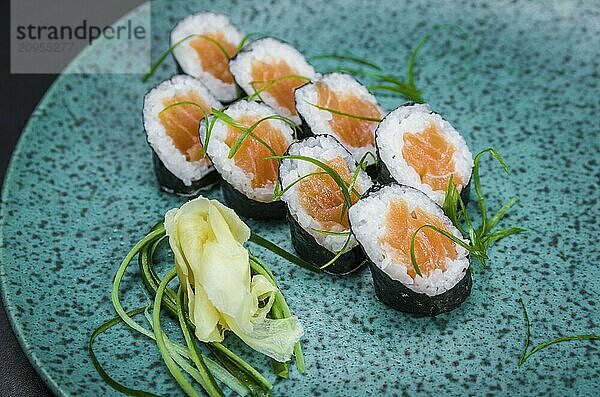 Perfektes Sushi  traditionelle japanische Küche. Leckere Hossomaki auf dem dekorierten Teller  schwarzer Hintergrund