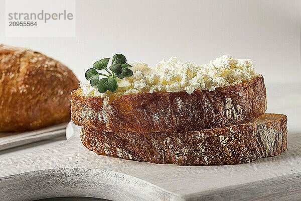 Sandwich  mit Frischkäse  hausgemacht  auf einem Schneidebrett  rustikal  ohne Menschen  selektiver Fokus  Frühstück