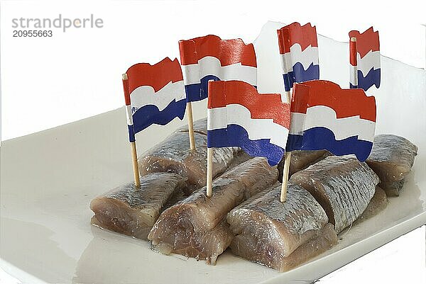 Den Helder  die Niederlande. Juni 2022. Frischer Hering mit Zwiebeln und niederländischen Flaggen auf weißem Hintergrund. Nahaufnahme. Selektiver Fokus