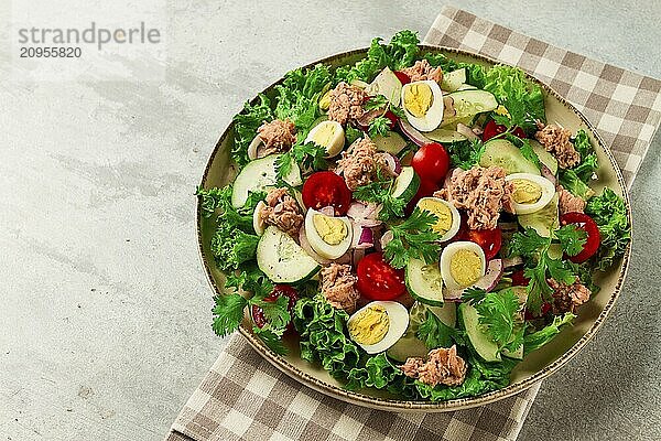 Thunfischsalat  Gemüsesalat mit Wachteleiern  Kopfsalat  roten Zwiebeln und Gurken  auf einem hellgrauen Tisch  Keto Food  Lifestyle  gesunde Ernährung  selektiver Fokus  Draufsicht  keine Menschen