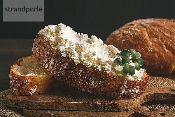 Sandwich  mit Frischkäse  hausgemacht  auf einem Schneidebrett  rustikal  ohne Menschen  selektiver Fokus  Frühstück