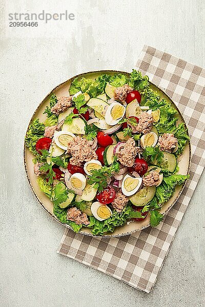 Thunfischsalat  Gemüsesalat mit Wachteleiern  Kopfsalat  roten Zwiebeln und Gurken  auf einem hellgrauen Tisch  Keto Food  Lifestyle  gesunde Ernährung  selektiver Fokus  Draufsicht  keine Menschen