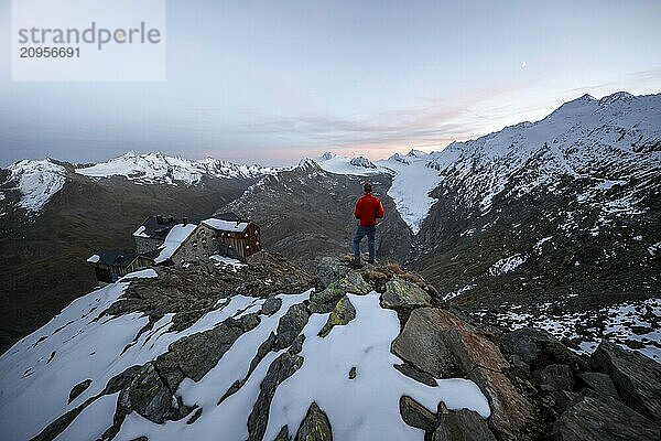 Wanderer blickt auf Bergpanorama und Gletscher  Berghütte Ramolhaus im Herbst mit Schnee  bei Sonnenuntergang  Blick auf Gurgler Ferner mit Gipfel Hochwilde und Falschungsspitze  Ötztaler Alpen  Tirol  Österreich  Europa