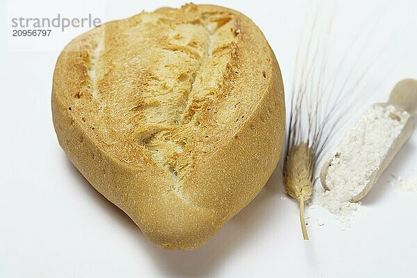 Weiches Brot mit Mehl  Weizenähren und einem Nudelholz vor weißem Hintergrund und Kopierraum