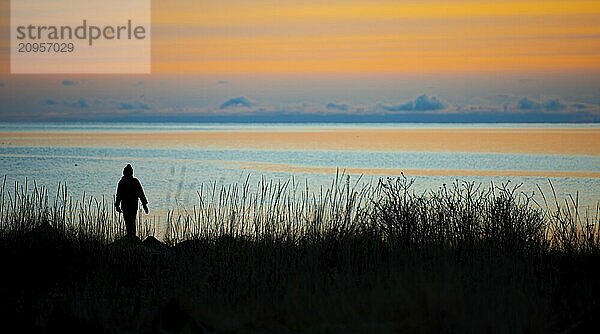 Silhouette einer Person am Strand bei Sonnenuntergang