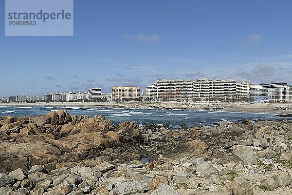 Felsen vor Stadtansicht mit Sandstrand und Brandung im Atlantik  Sehenswürdigkeit She Changes  Rotunda da Anémona  Skulptur der Künstlerin Janet Echelman an der Strandpromenade am Strand Praia de Matosinhos in Matosinhos  Region Norte  Distrikt Porto  Portugal  Europa