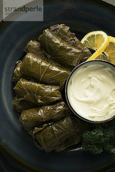 Dolma  Kohlrouladen  Traubenblätter mit Füllung  weiße Soße  Zitrone und Kräuter  rustikal  selektiver Fokus  keine Menschen