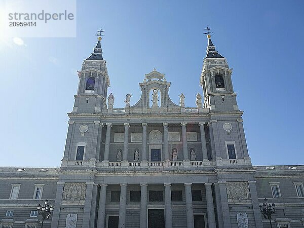 Frontal view of a church with high towers and a detailed façade under a cloudless sky  Madrid  Spain  Europe