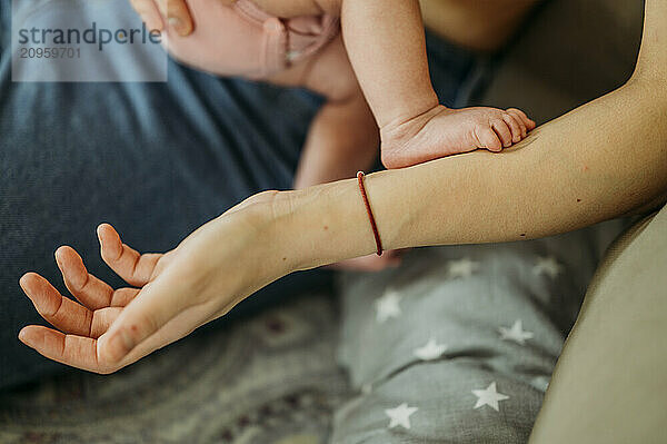 Leg of newborn baby girl on mother's hand