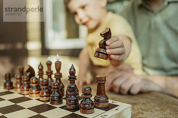 Hand of boy holding chess piece