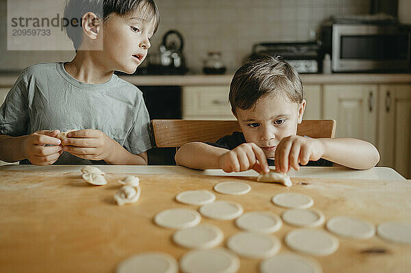 Siblings making dumpling at home